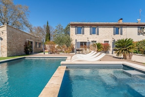A swimming pool with a stone building in the background. - Holiday Home “Mini Loft” with Shared Pool, Wi-Fi & Air Conditioning (Saint-Rémy-de-Provence)