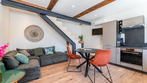Un espacio habitable moderno con una escalera, una zona de comedor y una cocina.