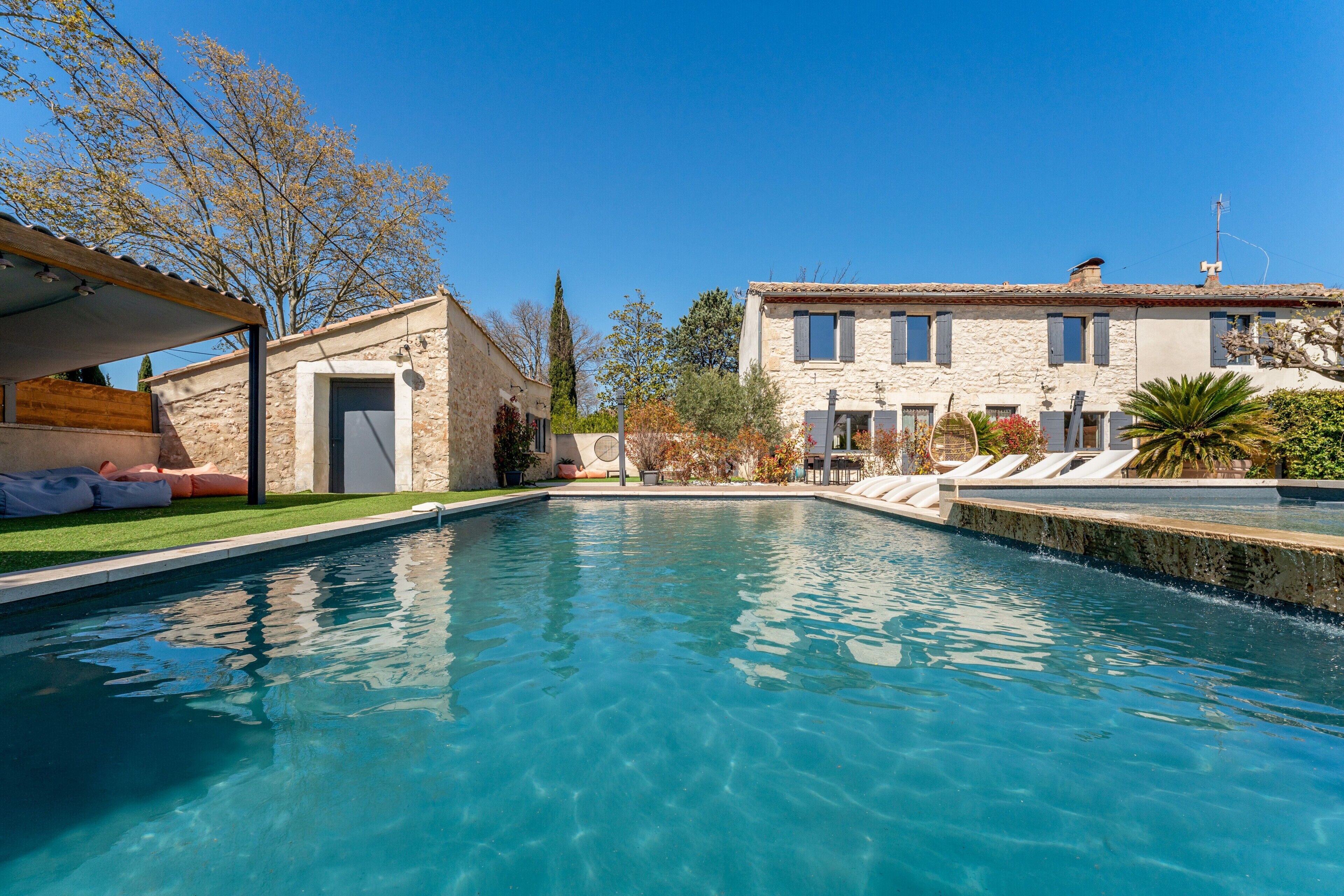 Une piscine avec un bâtiment en pierre en arrière-plan.