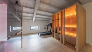 A spacious room with a wooden ceiling, a treadmill, and a glass partition. - La Casa di Caterina (Atripalda)