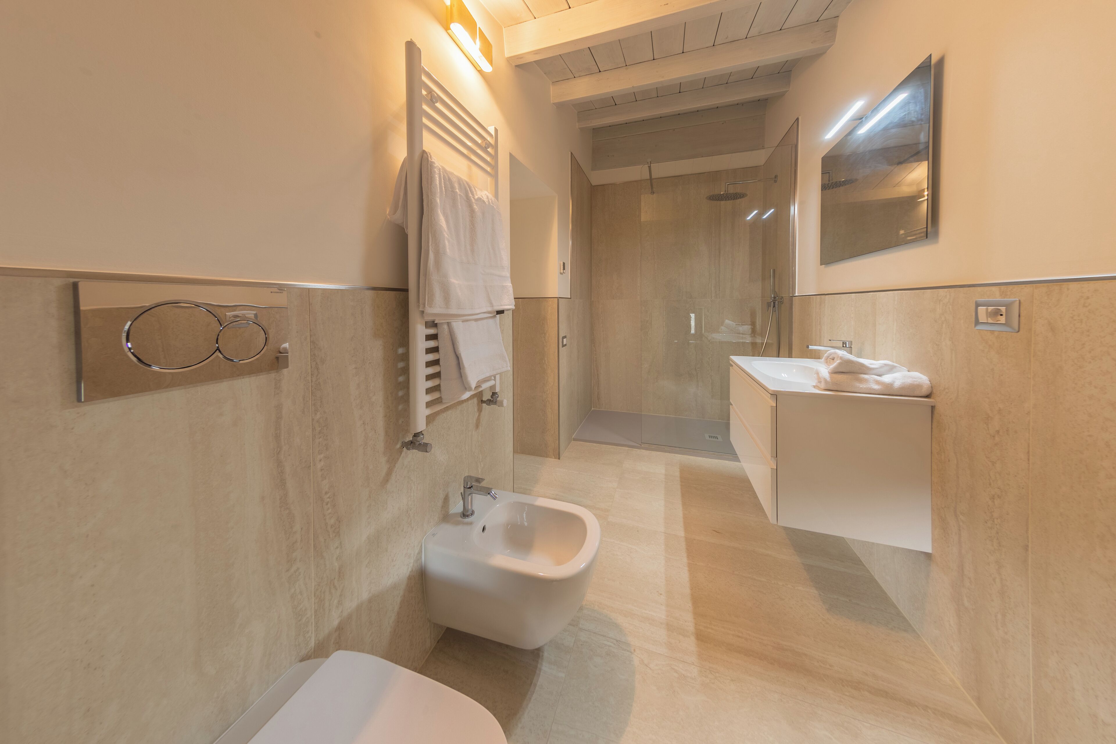 Een moderne badkamer met een toiletbril, een wastafel en een spiegel.