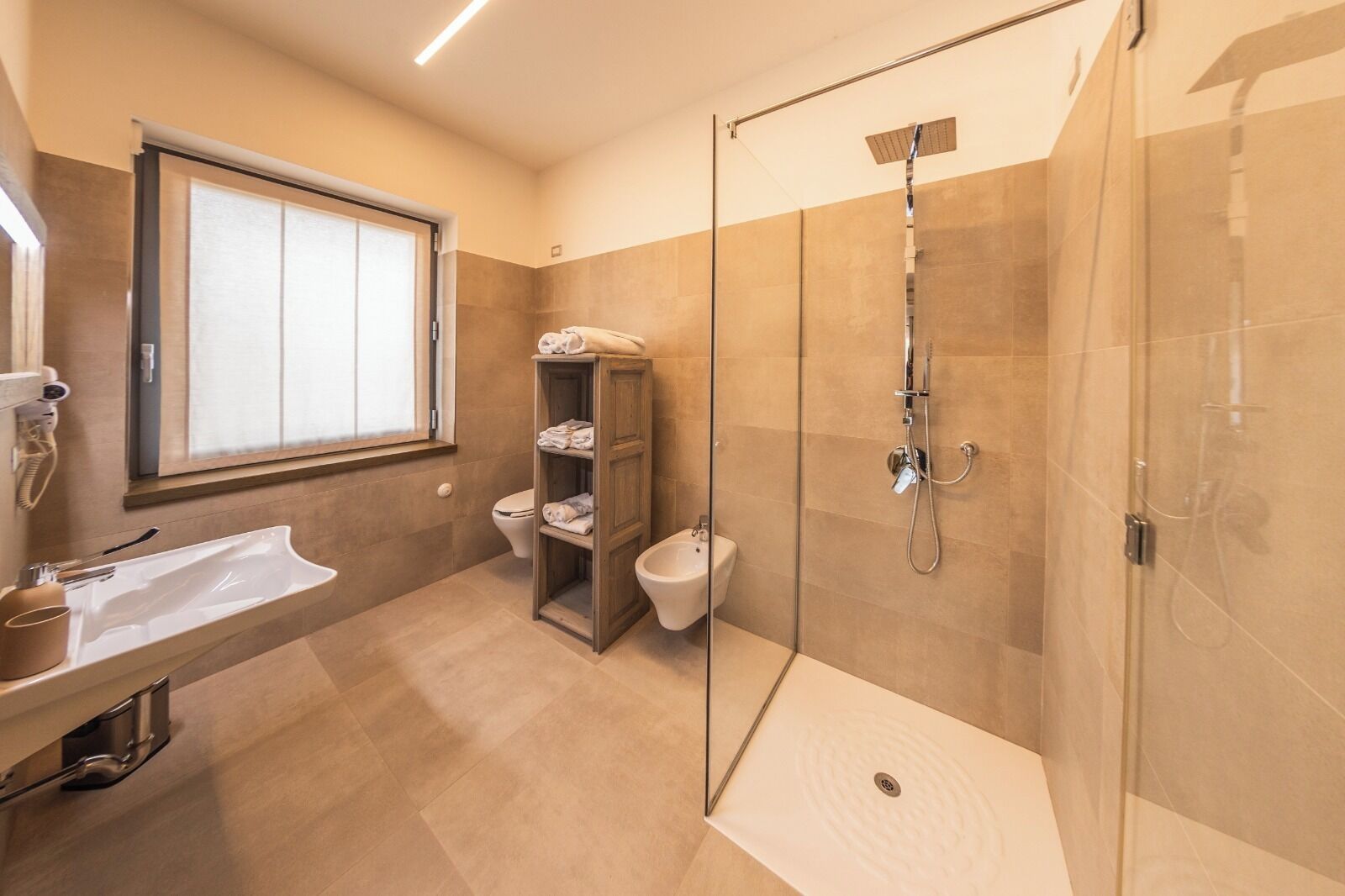 A modern bathroom with a glass-enclosed shower, a vanity with a sink, and a toilet.