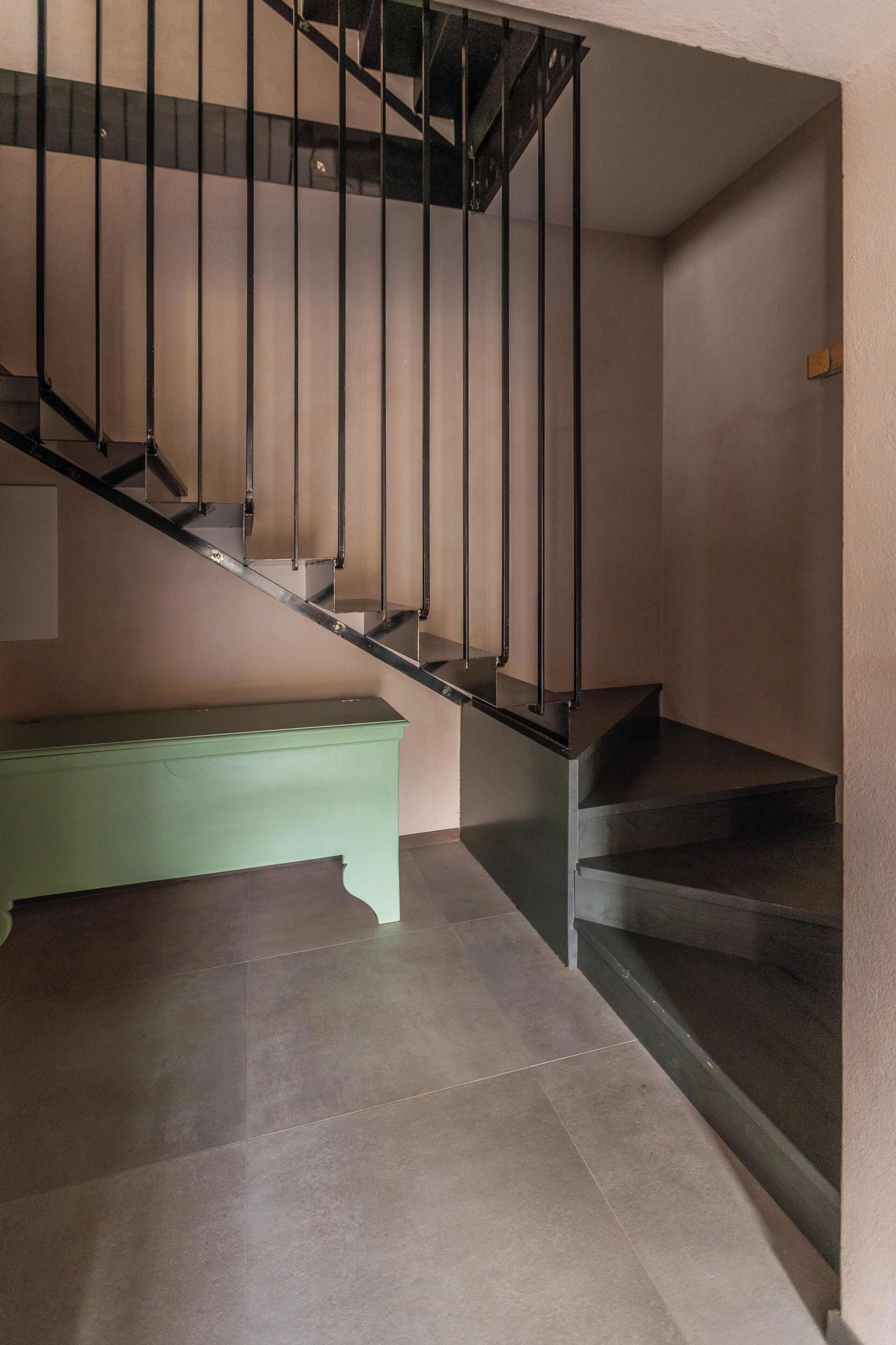 Eine Treppe mit einer grünen Bank am Fuß.