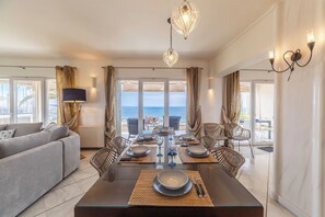 Un comedor moderno con una mesa grande dispuesta para seis personas, rodeada de sillas.