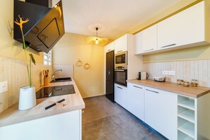 Eine moderne Küche mit weißen Schränken, einem schwarzen Backofen und einer Holz Arbeitsplatte.