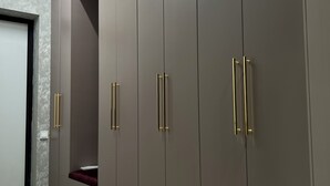 Un pasillo con un armario de pomos verticales y un suelo con diseño de mármol.