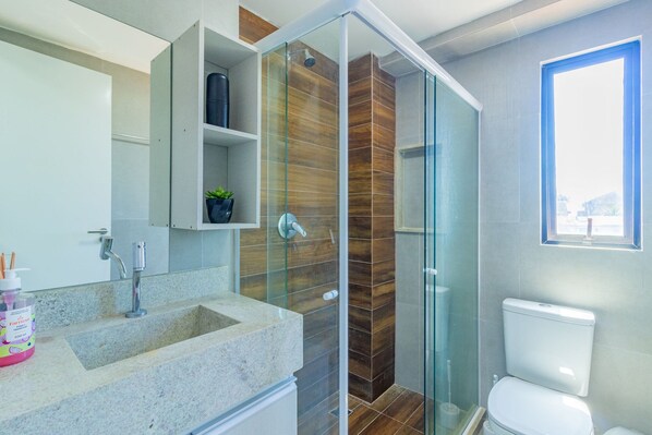 A modern bathroom with a glass shower enclosure, a built-in sink, and a toilet. - Villa Del Mar - Studios in Porto de Galinhas by Carpediem (Ipojuca)