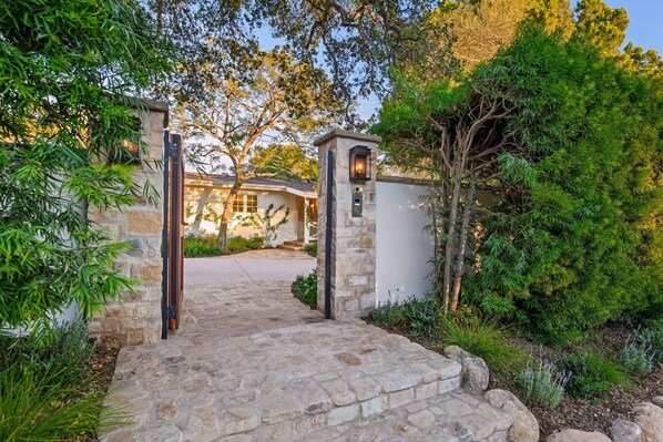 A stone pathway leading to a house with a stone gate and a lantern. - Montecito Luxury | Pickleball, Putting Green, Media Lounge, Hot tub & EV Charger (Montecito)