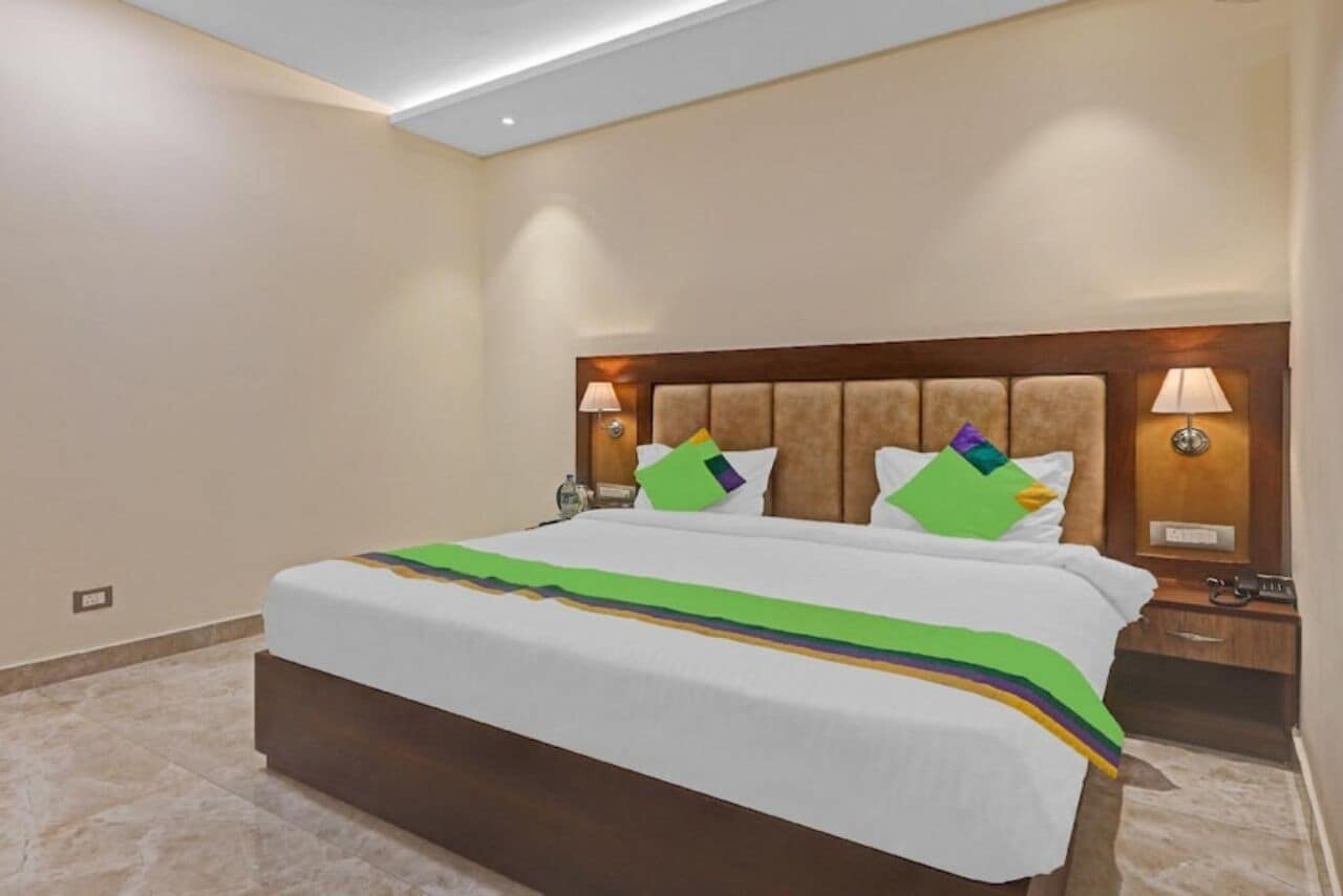 A hotel room with a large bed, two bedside tables, and a nightstand.