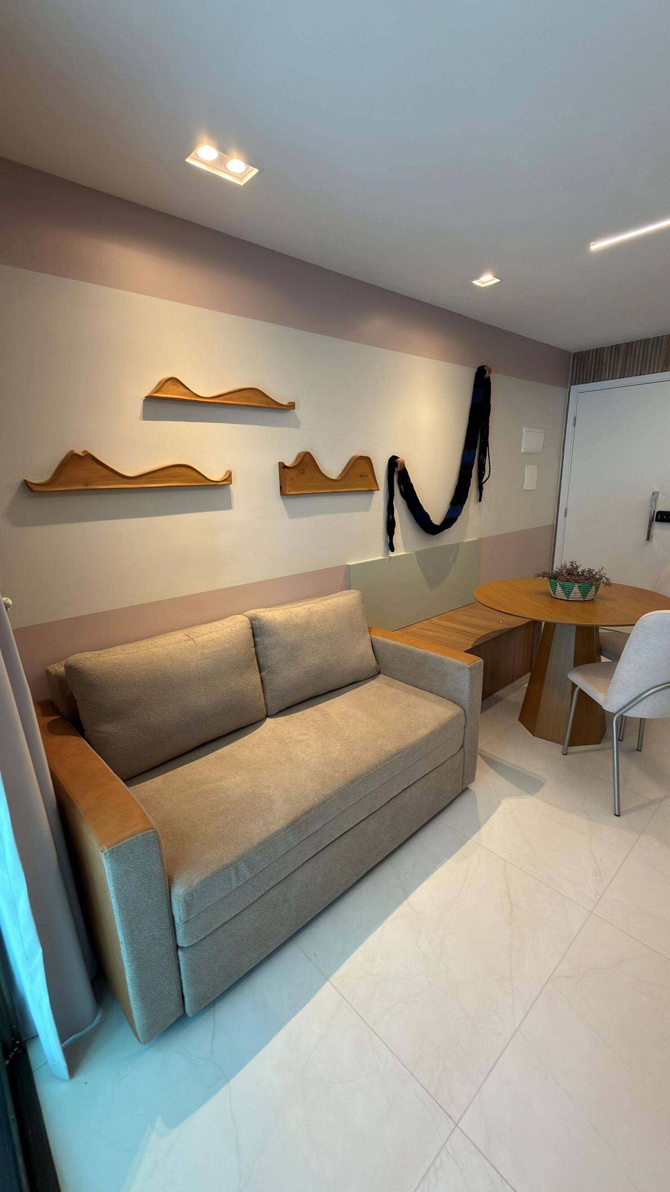 Uma sala de estar moderna com um sofá, uma mesa de madeira e uma cadeira.