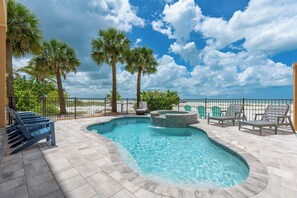 A swimming pool with lounge chairs, palm trees, and a view of the ocean. - 🌅Gulf Front Stunner | Private Pool + Spa | Elevator | Sunset Siesta🌅 (Fort Myers Beach)
