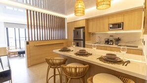 Een moderne keuken met een centraal eiland, barstoelen en een eethoek.