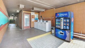 A hallway with a vending machine, a laundry area, and a door with a sign. - #216 Polynesian - WALK 2 PIER PARK you and beach (Upper Grand Lagoon)