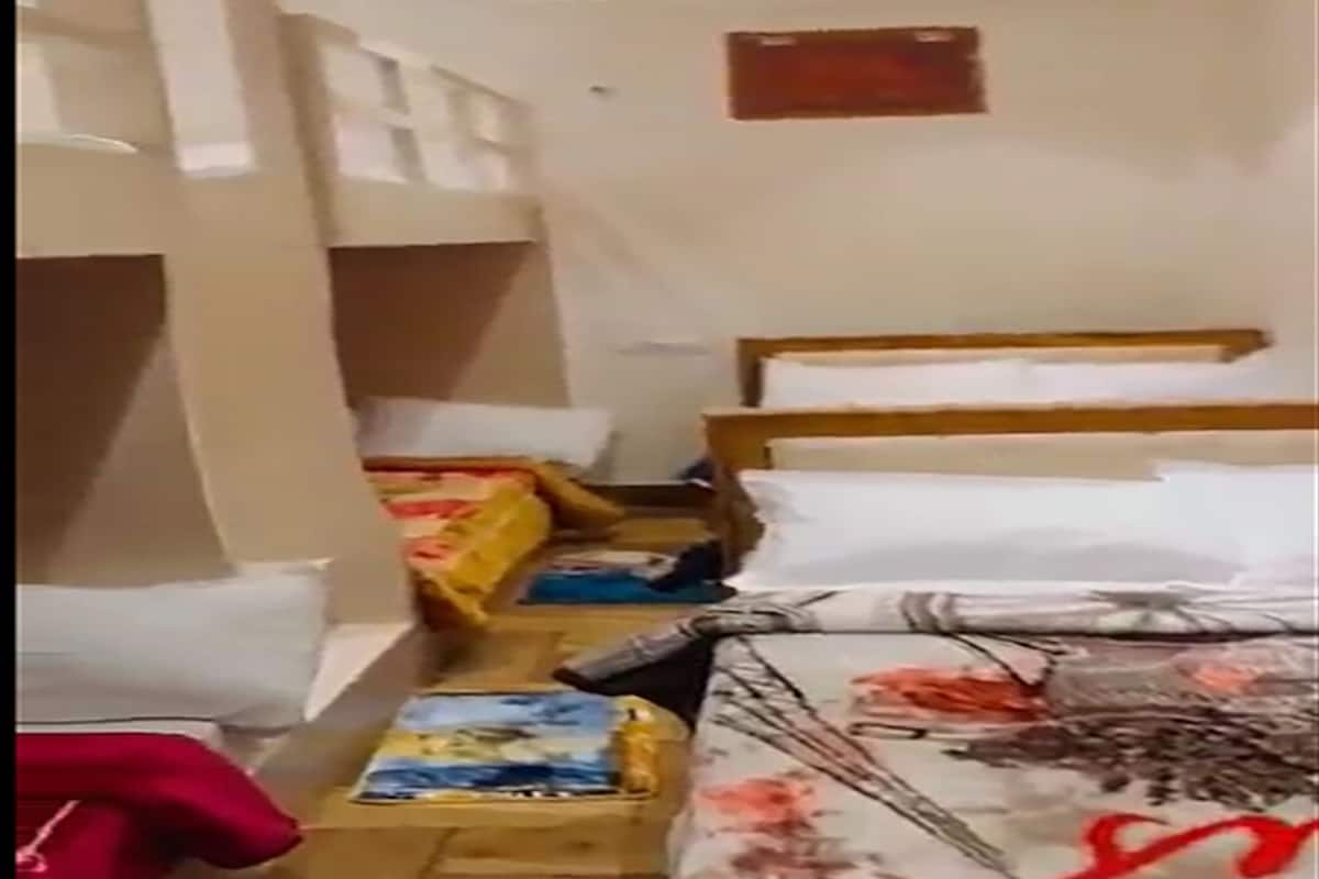 A room with bunk beds, a wooden headboard, and a ceiling fan.