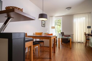 Ein moderner Essbereich mit Holztisch, Stühlen und einer Hängelampe.