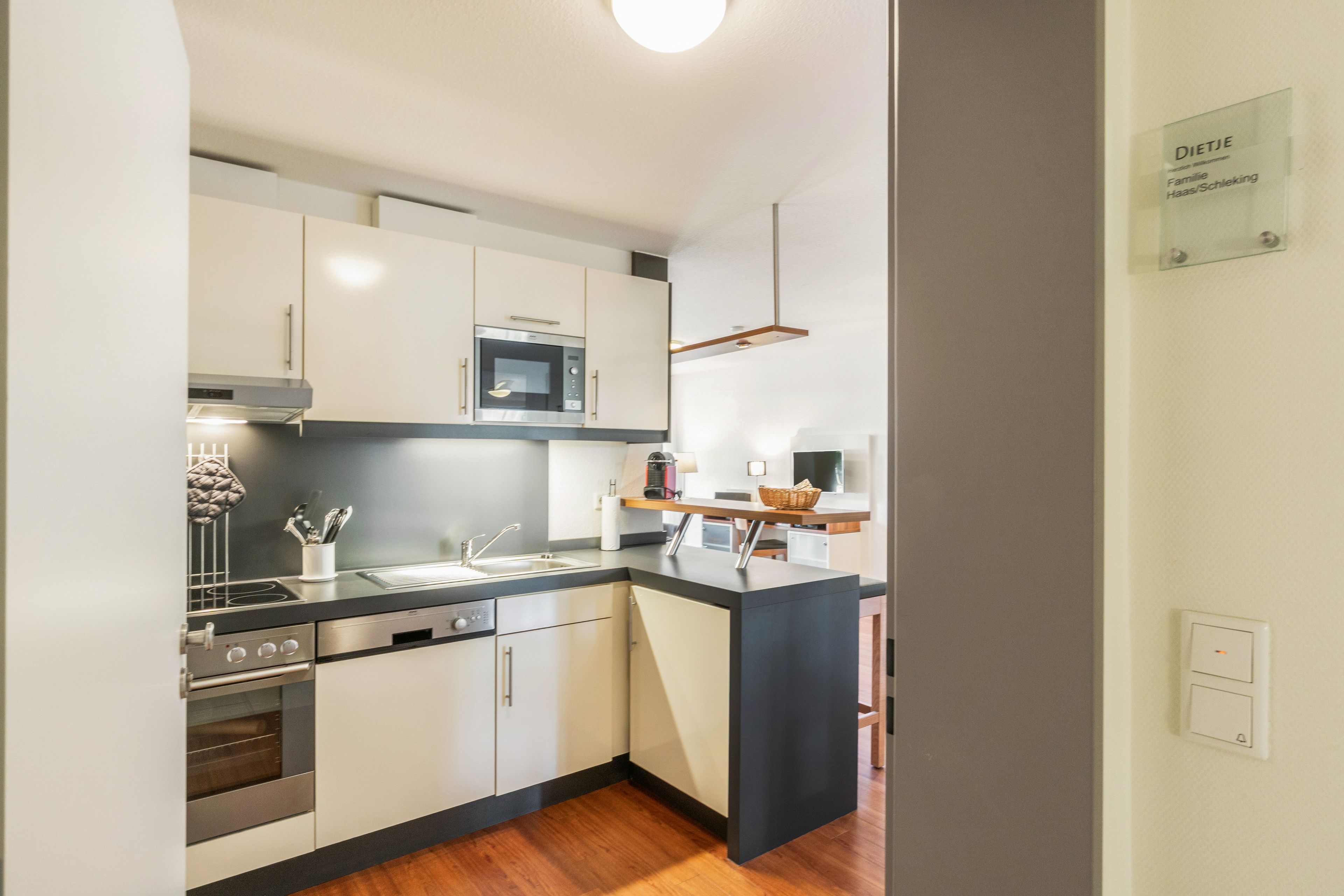 Una cocina moderna con electrodomésticos de acero inoxidable, horno empotrado y microondas.