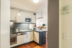 Een moderne keuken met roestvrijstalen apparatuur, een inbouwoven en een magnetron.