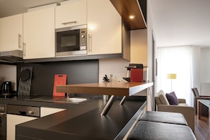 Eine moderne Küche mit Backofen, Kaffeemaschine und einem roten Schneidebrett.
