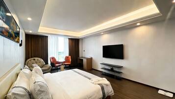Una habitación de hotel moderna con una cama grande, un escritorio, un televisor y dos sillas.