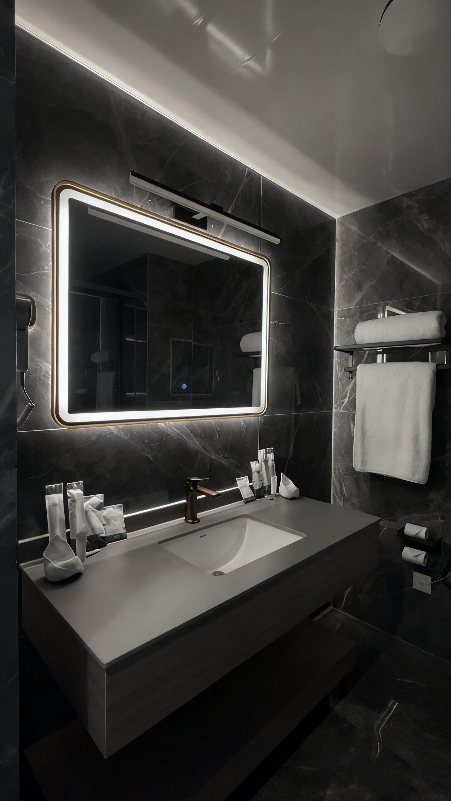 Un baño moderno con un espejo grande, dos lavamanos y un perchero para toallas.
