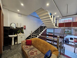 Un intérieur moderne avec un escalier, un canapé, un évier et un extincteur.