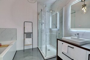 A modern bathroom with a glass-enclosed shower, a white sink, and a large mirror. - Condos Monts-Valin -153, rue du Massif (Valinouët) (Le Fjord-du-Saguenay Regional County Municipality)