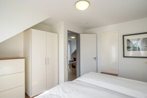 Ein Schlafzimmer mit Bett, Kleiderschrank und einer Tür zu einem Badezimmer.