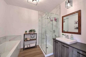 A modern bathroom with a glass shower enclosure, a wooden vanity, and a shelf with plants. - Condos Monts-Valin -151, rue du Massif (Valinouët) (Saint-David-de-Falardeau)