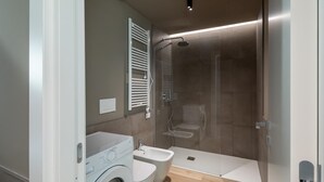 A modern bathroom with a built-in washing machine, a bidet, and a shower enclosure. - 13 -Villa Pignone Three-room Superior apartment with balcony (Genova)