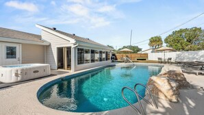 A swimming pool with a built-in hot tub, a covered patio area, and a wooden deck. - 90+ Day Furnished Retreat! Heated Pool, Spa, Game Room, and 4 King Beds! (Merritt Island)