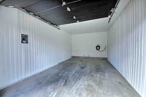 A large, empty industrial-style room with corrugated metal walls and a concrete floor. - Condos Monts-Valin -163, rue du Massif (Valinouët) (Saint-David-de-Falardeau)
