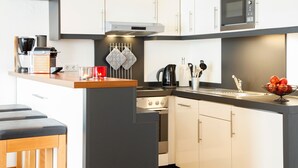 Ett modernt kök med inbyggd ugn, mikrovågsugn och kaffebryggare.
