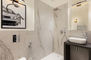 A modern bathroom with a large mirror, a white sink, and a shower. - Eden Rooms Vert (Stresa)