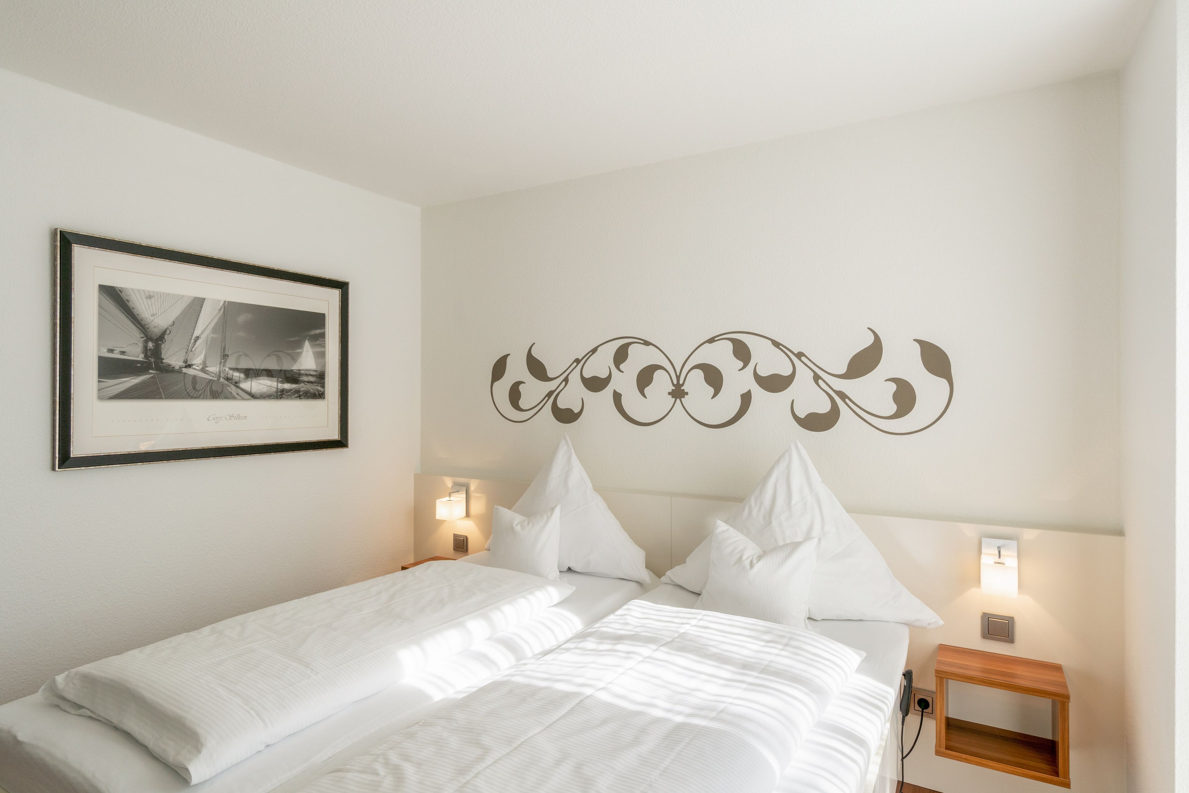 Ein ordentlich bezogenes Bett mit weißen Leinen in einem Hotelzimmer.