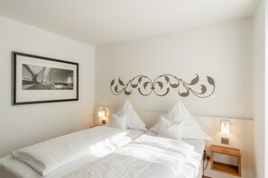 Ein ordentlich bezogenes Bett mit weißen Leinen in einem Hotelzimmer.