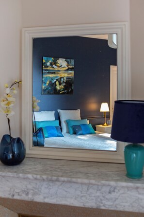 A bedroom with a bed, pillows, a nightstand, a lamp, a vase with flowers, and a painting on the wall. - La petite bastide de Trevouse, 4 stars with swimming pool (Entraigues-sur-la-Sorgue)