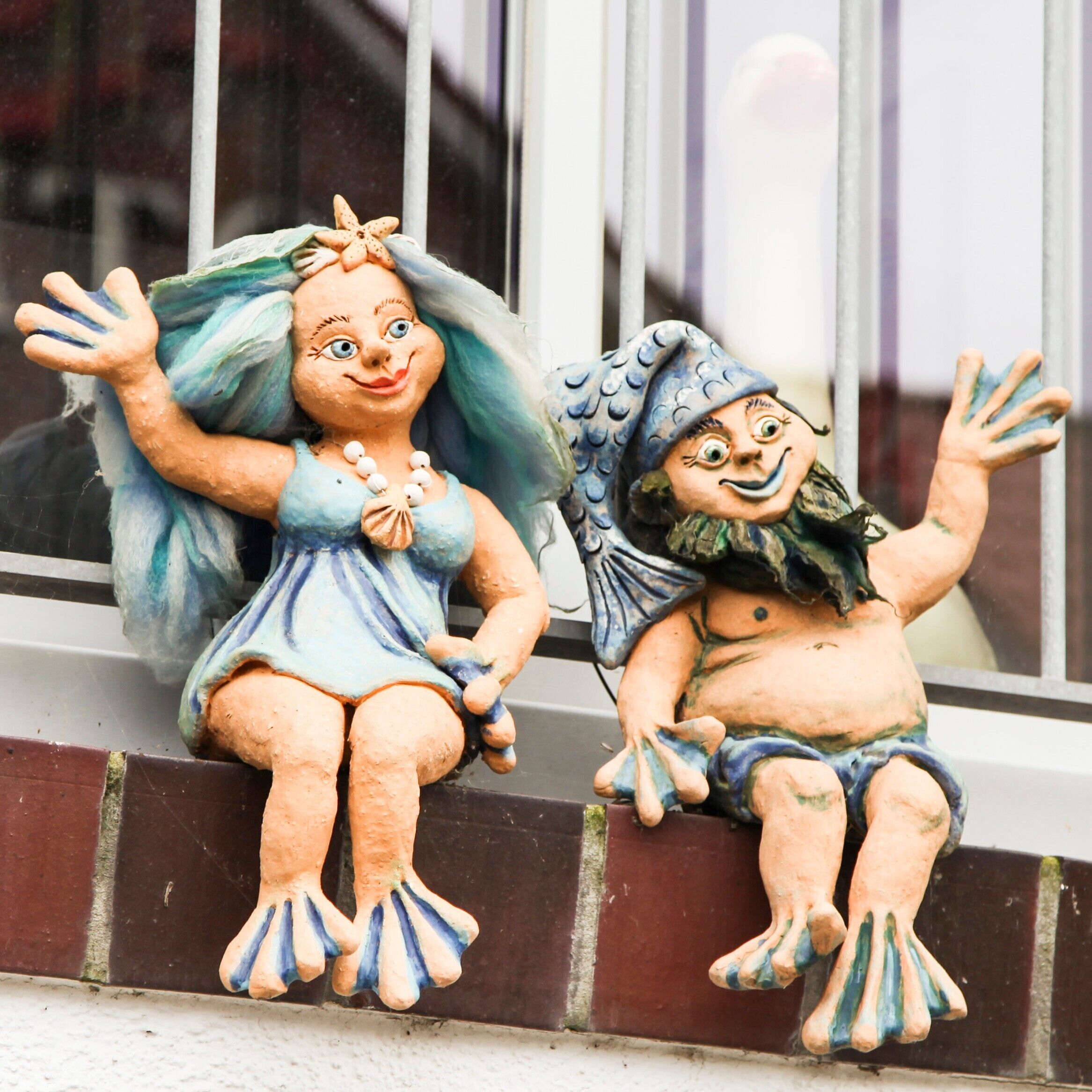 Duas figuras de cerâmica em um parapeito.