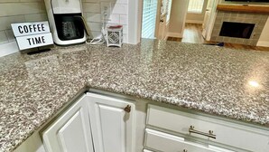 A kitchen with white cabinets, a granite countertop, and a coffee maker. - Near McKinney Square!  Charming 3 BR house with garage and huge yard (McKinney)