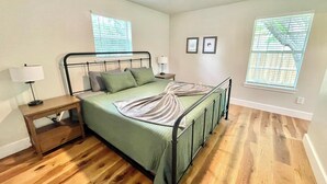 A bedroom with a bed, nightstands, a ceiling fan, and windows with blinds. - Near McKinney Square!  Charming 3 BR house with garage and huge yard (McKinney)