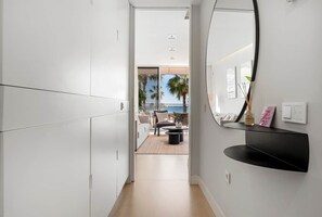 A modern hallway with white cabinetry, a black console table, and a large mirror. - Casa Costa Tropical (Estepona)