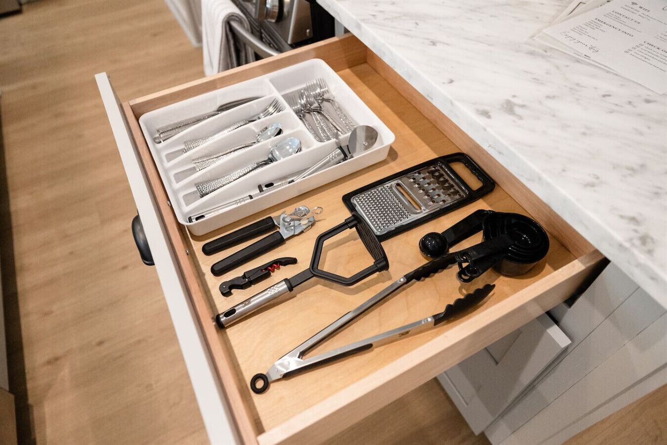 A kitchen drawer containing various utensils and appliances.