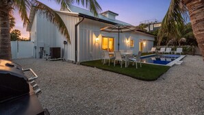 A modern house with a swimming pool, outdoor seating, and a barbecue area. - Honey I'm Holmes - New Home Near the Beach! Turf (Holmes Beach)