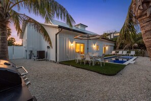A modern house with a swimming pool, outdoor seating, and a barbecue area. - Honey I'm Holmes - New Home Near the Beach! Turf (Holmes Beach)