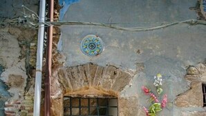 A stone building entrance with a tiled floor and a decorative tile pattern around the door. - La Luna sul Porto by Biddizzi Rari - at the port, near the sea and the center (Sciacca)