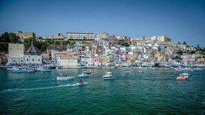 A coastal town with a densely packed hillside of buildings, a marina with various boats, and a clear blue sky. - La Luna sul Porto by Biddizzi Rari - at the port, near the sea and the center (Sciacca)