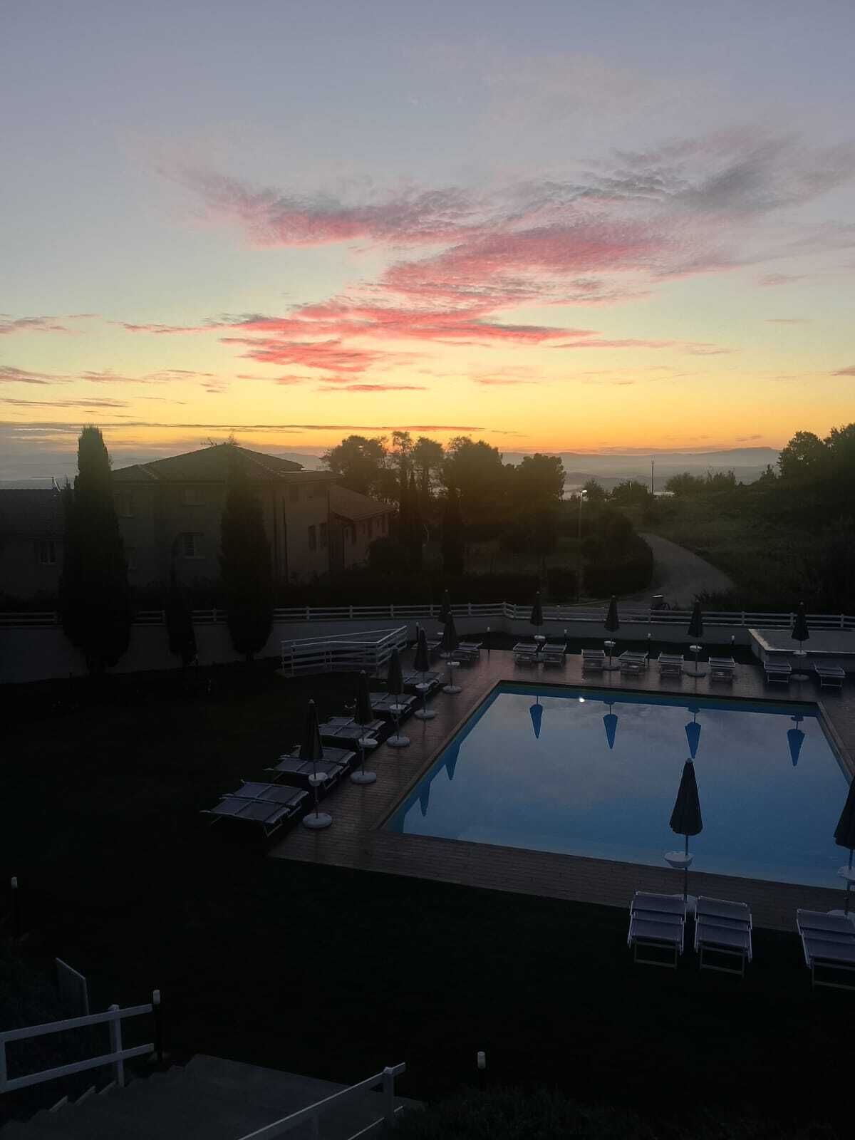 Una piscina al aire libre de temporada, sombrillas, tumbonas