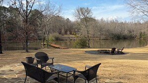 A patio with stone flooring, a table, and chairs. - Cozy 1-bedroom peaceful pond cabin minutes from town (Gray)