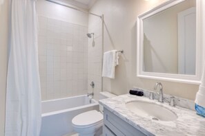 Ein Badezimmer mit Badewanne, Toilette und Waschbecken.