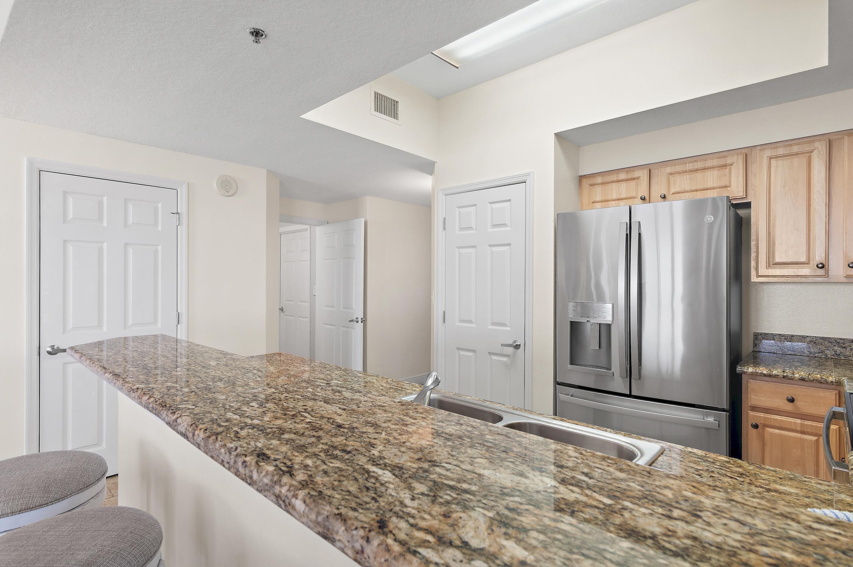 A kitchen with granite countertops, stainless steel appliances, and wooden cabinets.