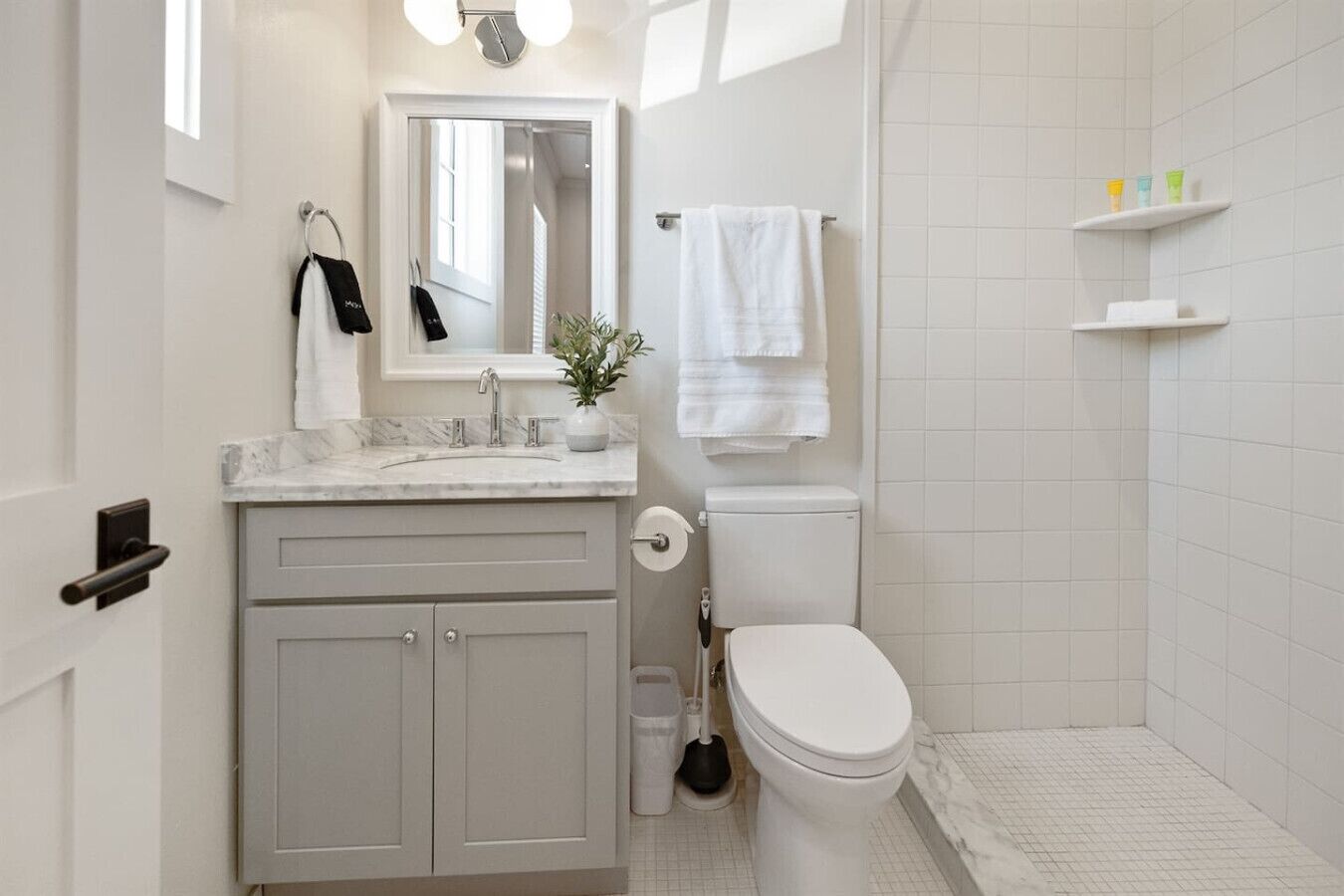 Een moderne badkamer met een marmeren wastafel, toilet en douchegedeelte.